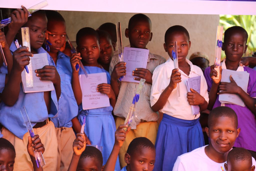 School kids show of the books and pens received 