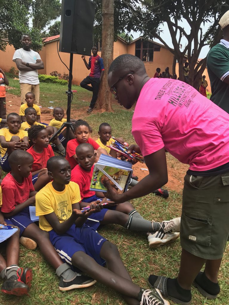 Handing pens, pencils, and books to needy school kids