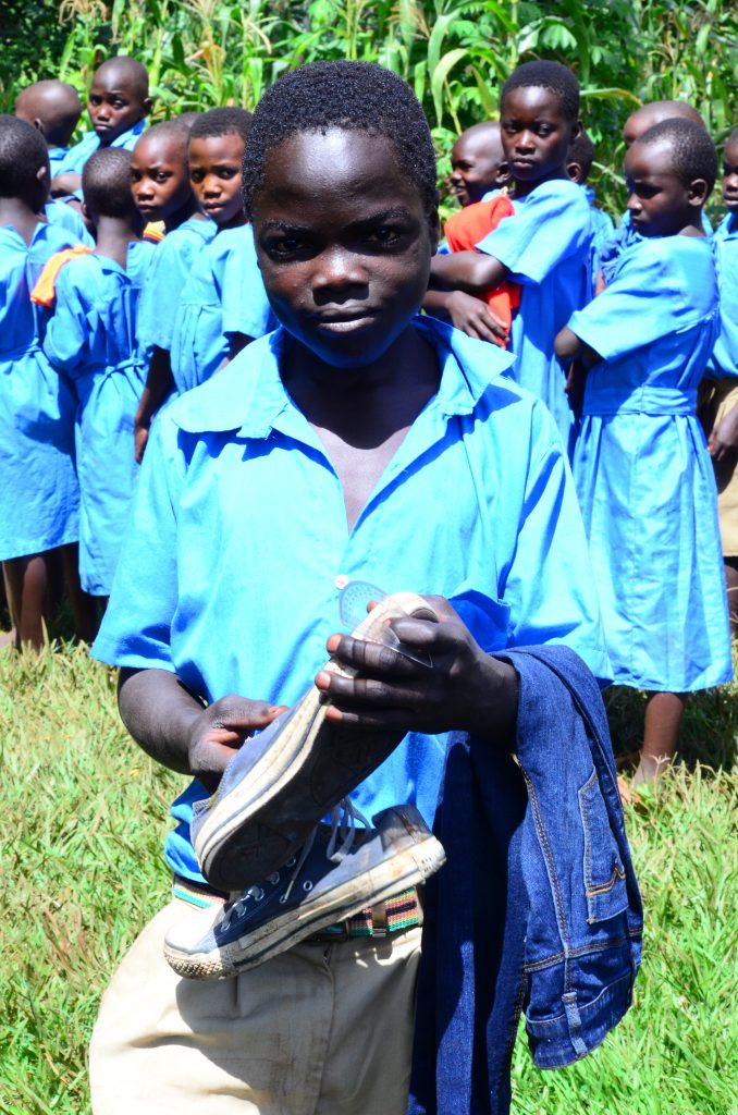 A school boy happy to receive a new pair of shoes