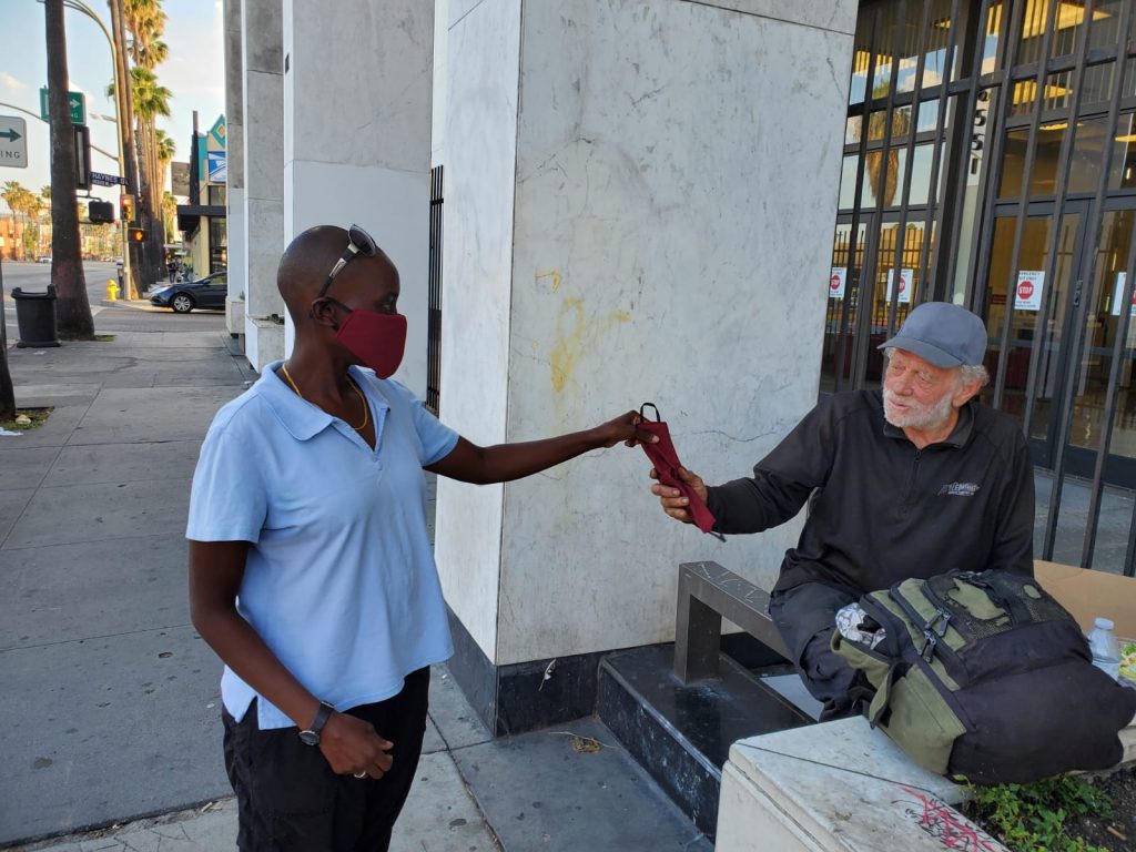 A homeless man in Los Angeles receiving a face mask