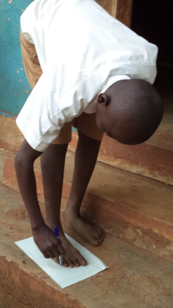 A school boy taking measurement to receive a pair of new shoes