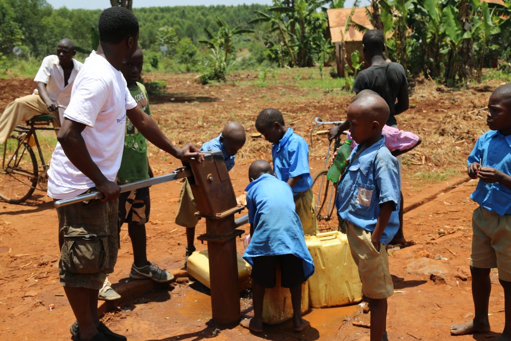 At the borehole drawing water